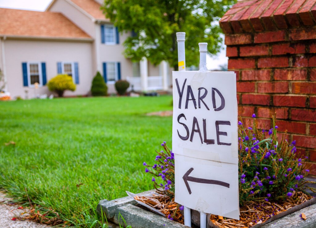 A holme made yard sale sign with an arrow pointing toward a yard.